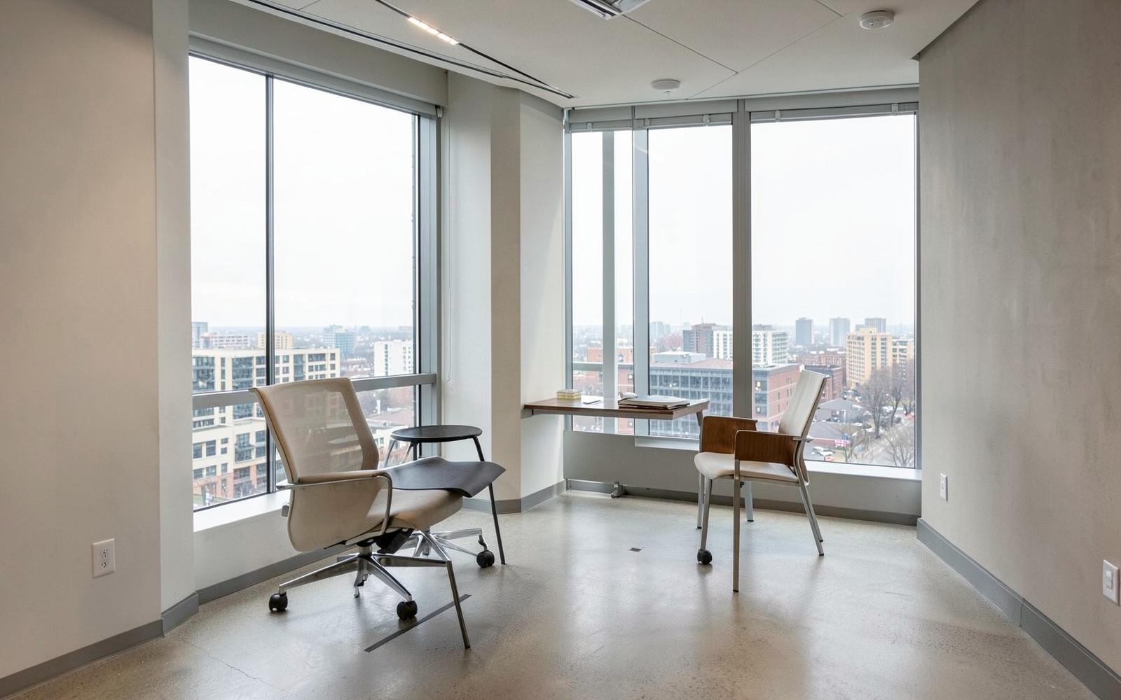 Quiet meeting room with two chairs beside a window overlooking the city